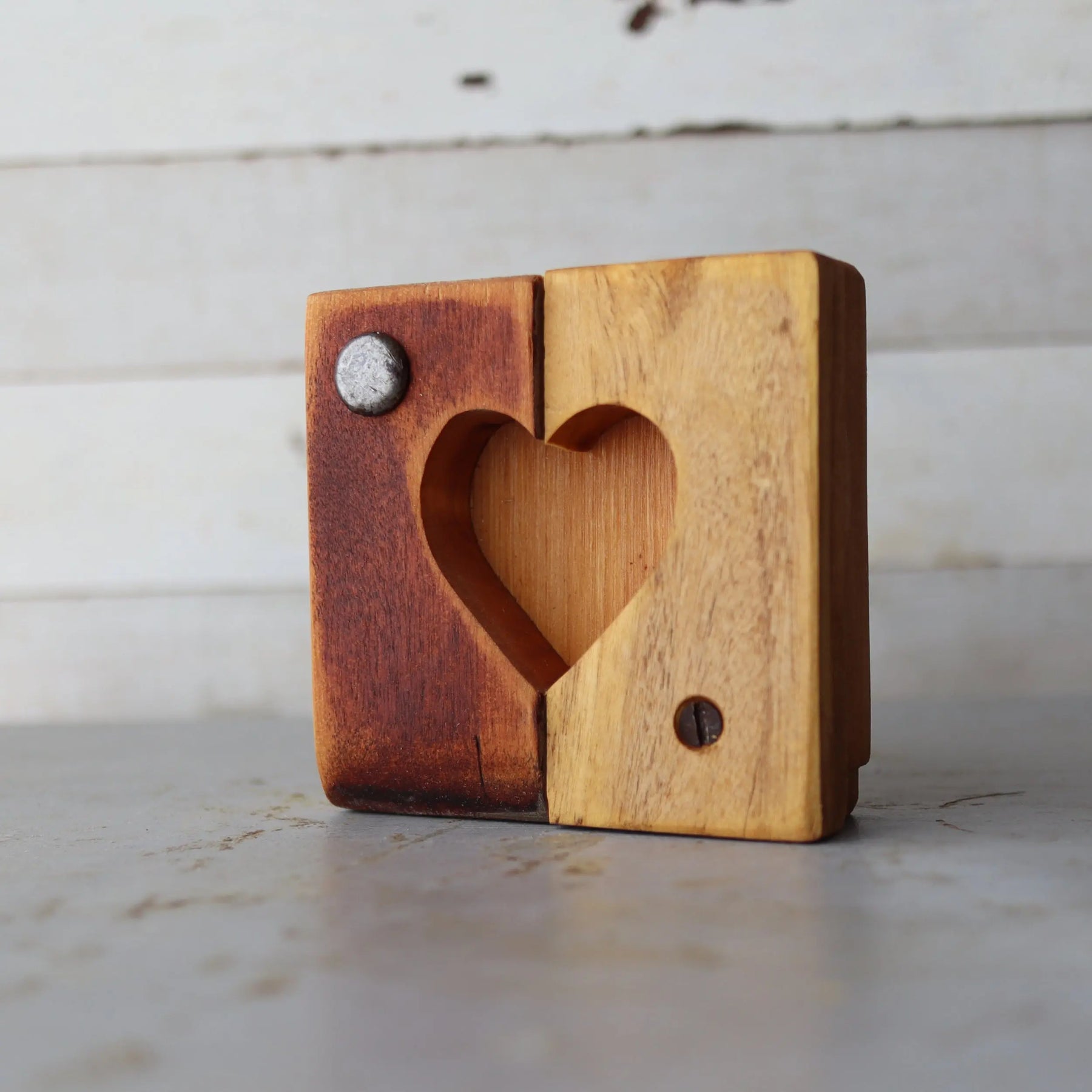 Two-toned wooden heart-shaped tile with visible screws.