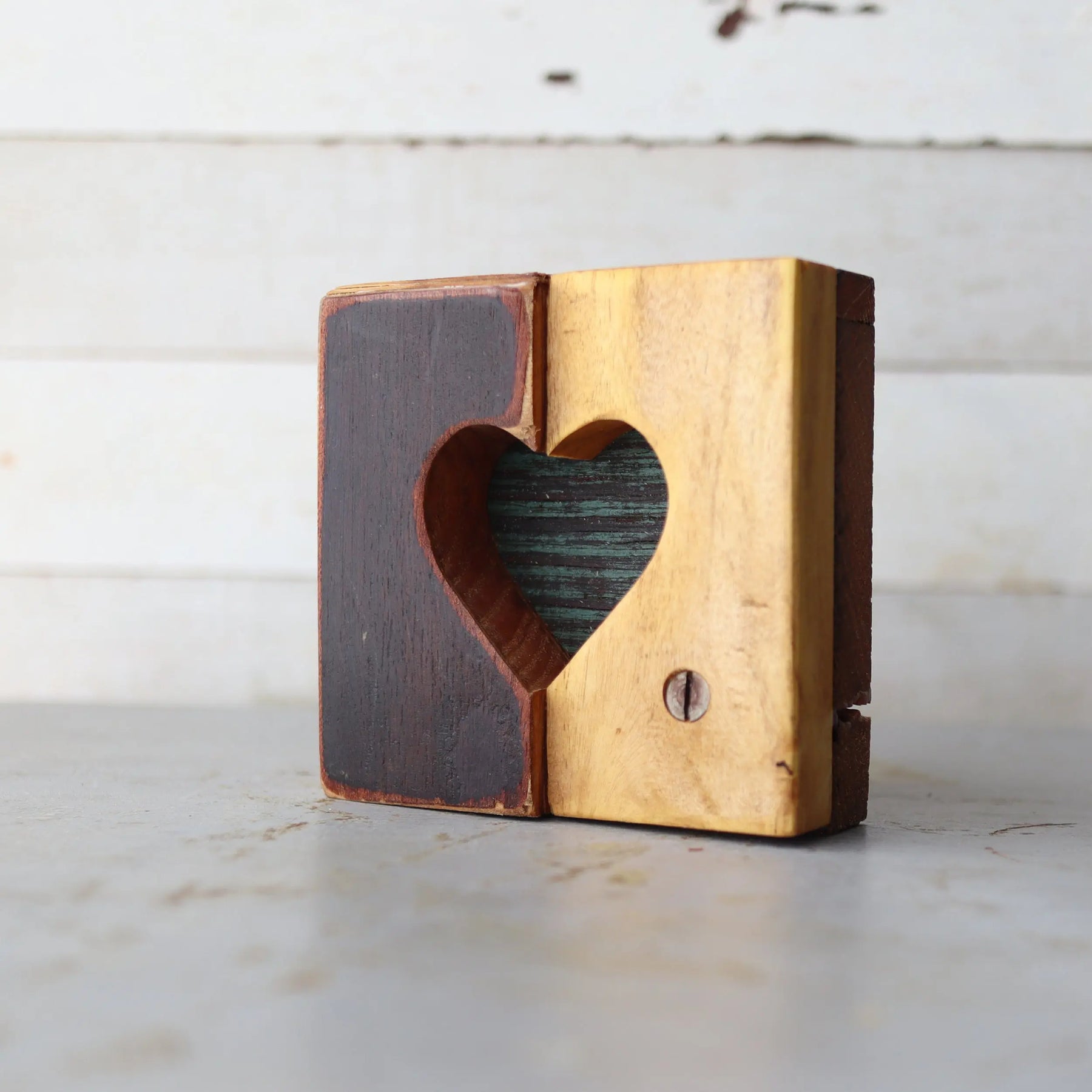 Two-toned wooden heart cutout block with a distressed background.