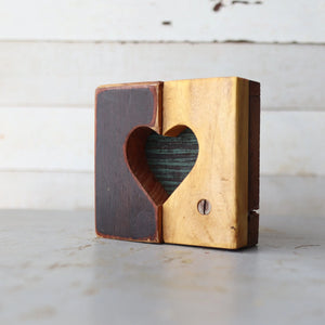 Two-toned wooden heart cutout block with a distressed background.