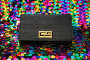 Black Ruth Clutch handbag with gold GG logo on a colorful sequin background
