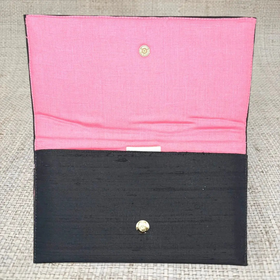 Black clutch with pink lining and gold snap closure