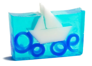Transparent blue soap slice with white sailboat and blue wave rings