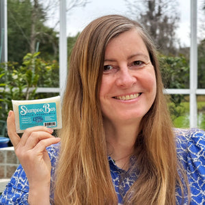 Woman holding a "Shampoo Bar" Vanilla Coconut Milk product by Essential Journeys.