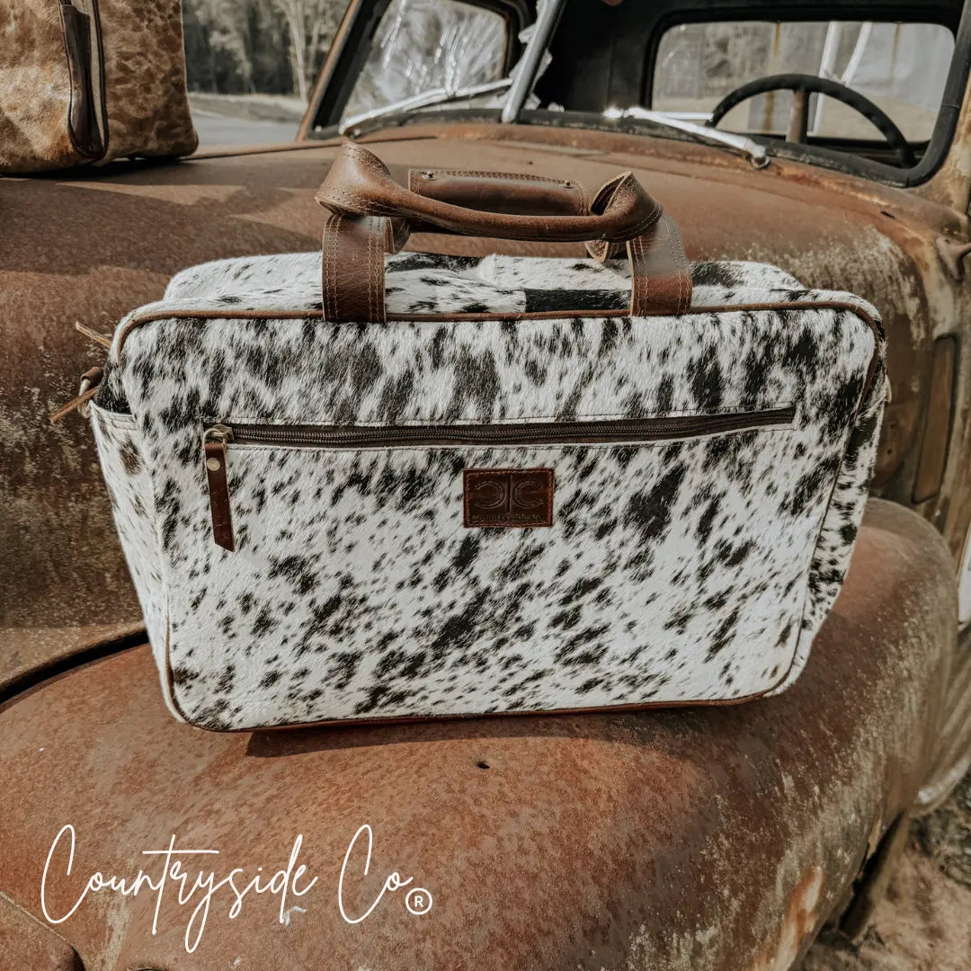 Saddlemen carry all cowhide duffle travel bag with brown leather handles and zipper pockets.