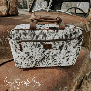 Saddlemen carry all cowhide duffle travel bag with brown leather handles and zipper pockets.