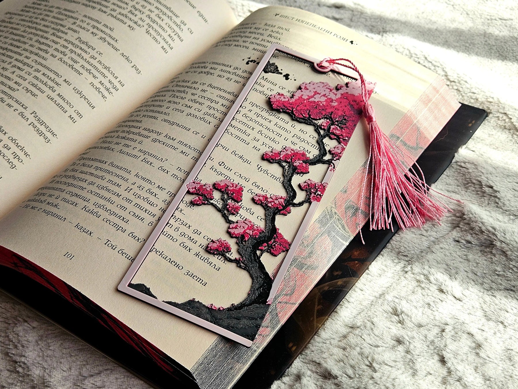 Cherry Blossom Bookmark: Framed bookmark with pink cherry blossoms on a tree design in an open book with a pink tassel.  