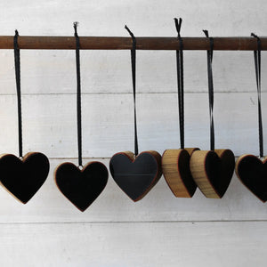 Wooden heart ornaments with black faces hang from black ribbons.