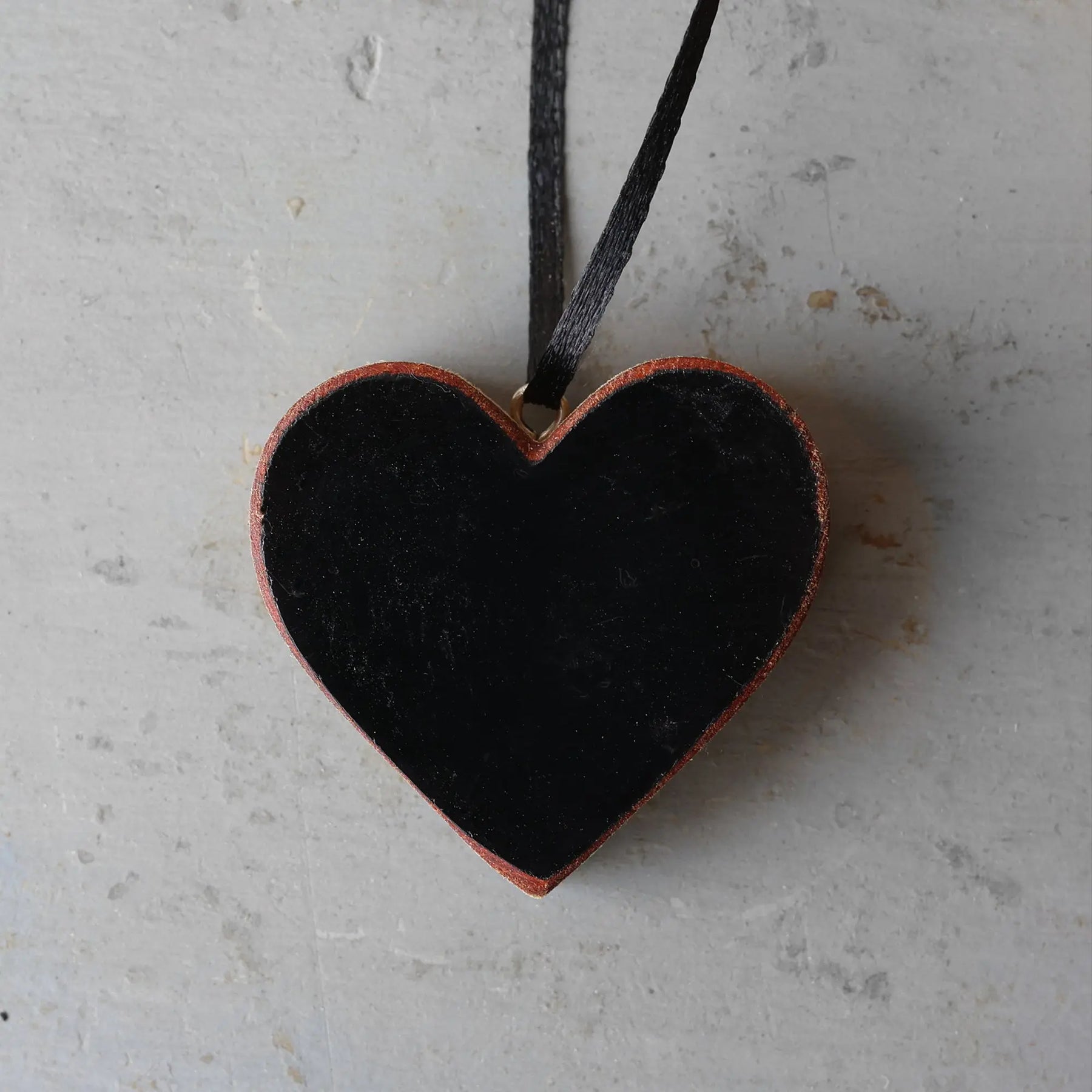 Black heart ornament made from reclaimed Steinway piano wood with a black ribbon hanger.