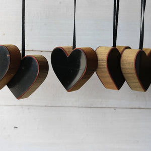 Steinway Piano Heart Ornaments made of wood with black centers and ribbon hangers.