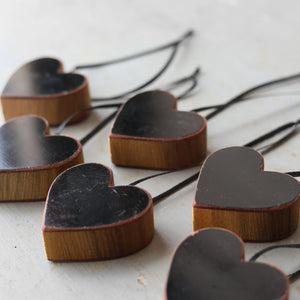 Steinway piano heart ornaments with black tops and wooden sides on strings.