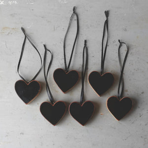 Black heart-shaped ornaments made from reclaimed Steinway piano wood hanging by ribbons.
