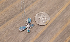 Sterling silver butterfly pendant with colorful inlay next to a U.S. quarter for scale.