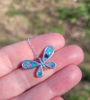 Sterling silver butterfly pendant with colorful inlay on a hand. Memorial ashes jewelry held in palm.
