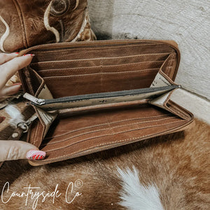 Brown leather wallet with zipper closure and interior card slots.