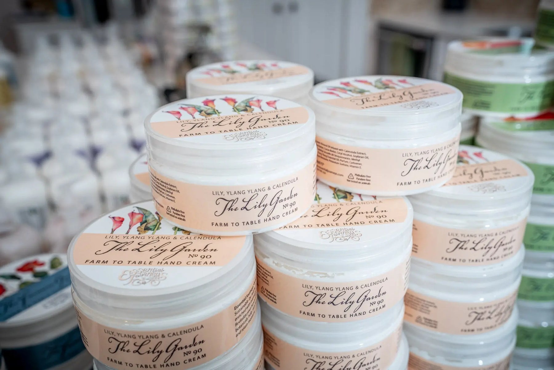 Stacked jars of The Lily Garden hand cream with floral labels.