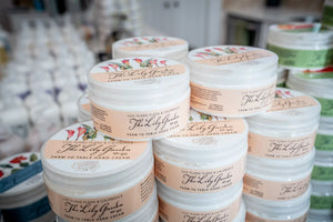 Stacked jars of The Lily Garden hand cream with floral labels.