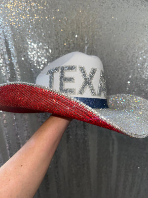 White cowboy hat with "TEXANS" in silver rhinestones, red and silver brim