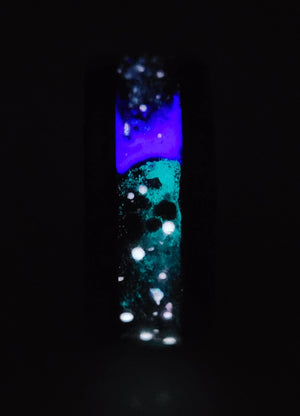Memorial ring with ashes, black onyx mica powder, purple glow, and star constellations embedded in a black ceramic band.