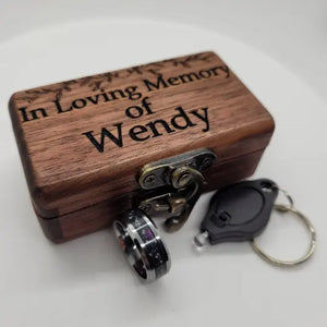 Memorial ring with ashes, purple glow, and star constellations, with wooden box and UV light keychain.