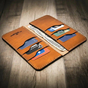 Brown leather long wallet open with credit cards and cash on a wooden surface.