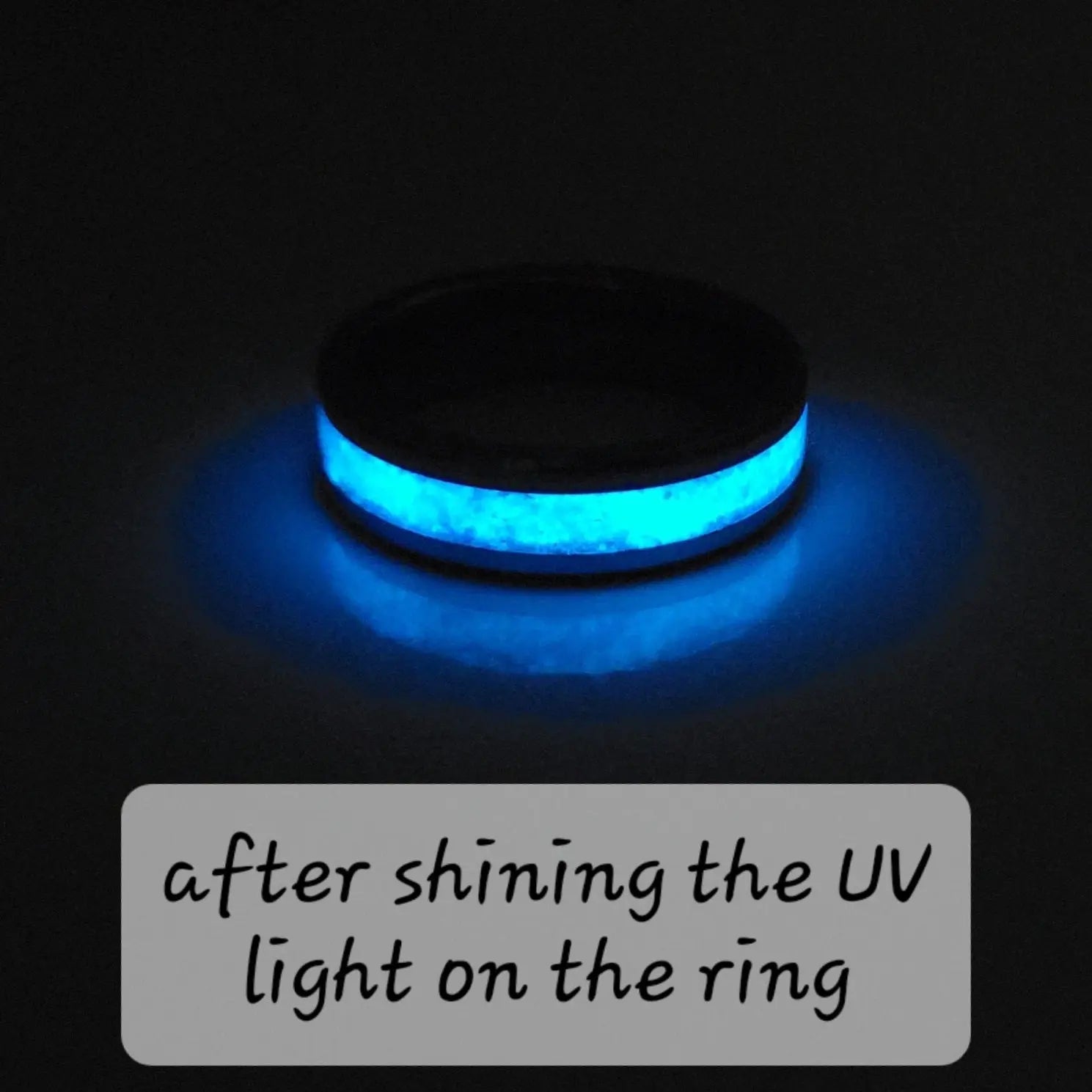 Glowing blue ring illuminated by UV light. Dark band with bright blue center.