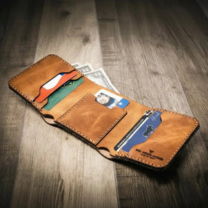 Brown leather trifold wallet with credit cards and cash inside.