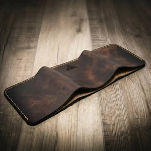 Brown leather trifold wallet with visible stitching and embossed logo.