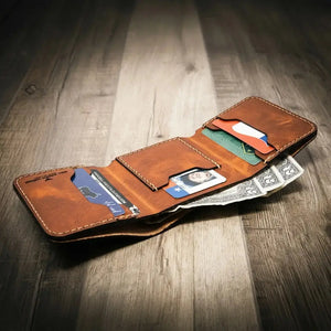 Brown leather trifold wallet with US driver's license, credit cards, and cash.