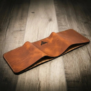 Brown leather trifold wallet with stitched edges and embossed logo.