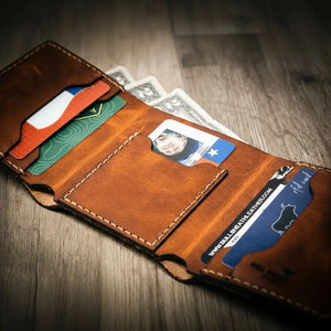 Brown leather trifold wallet with cards and cash visible