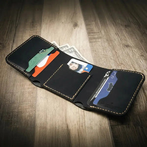 Black leather trifold wallet with cards and cash on a wooden surface.