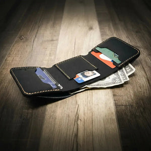 Black leather trifold wallet open with credit cards and cash visible