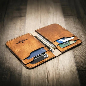 Brown leather vertical wallet with cards and cash on a wooden background.