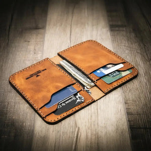 Brown leather vertical wallet holding credit cards and folded cash.