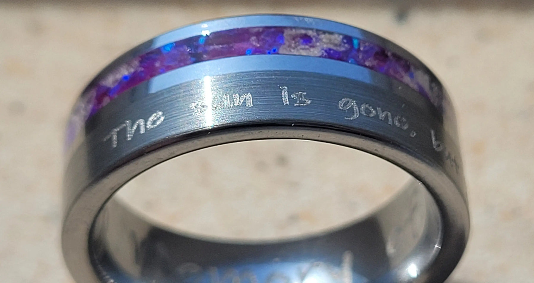 Engraved tungsten memorial ring with purple inlay featuring ashes.