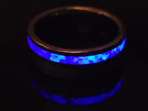 Tungsten ring with blue glow inlay and reflection in a dark setting.
