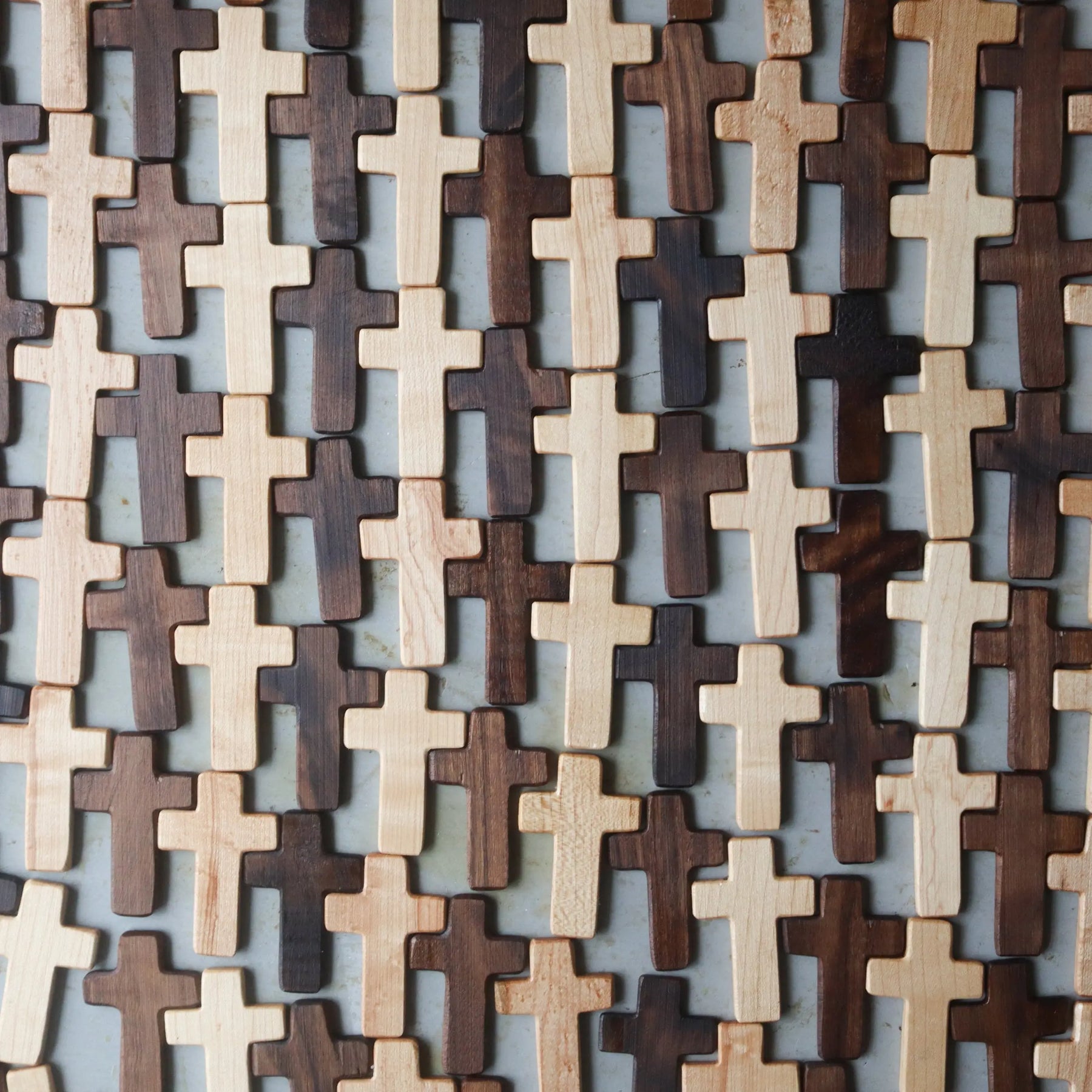Pile of small wooden crosses in light and dark wood tones.