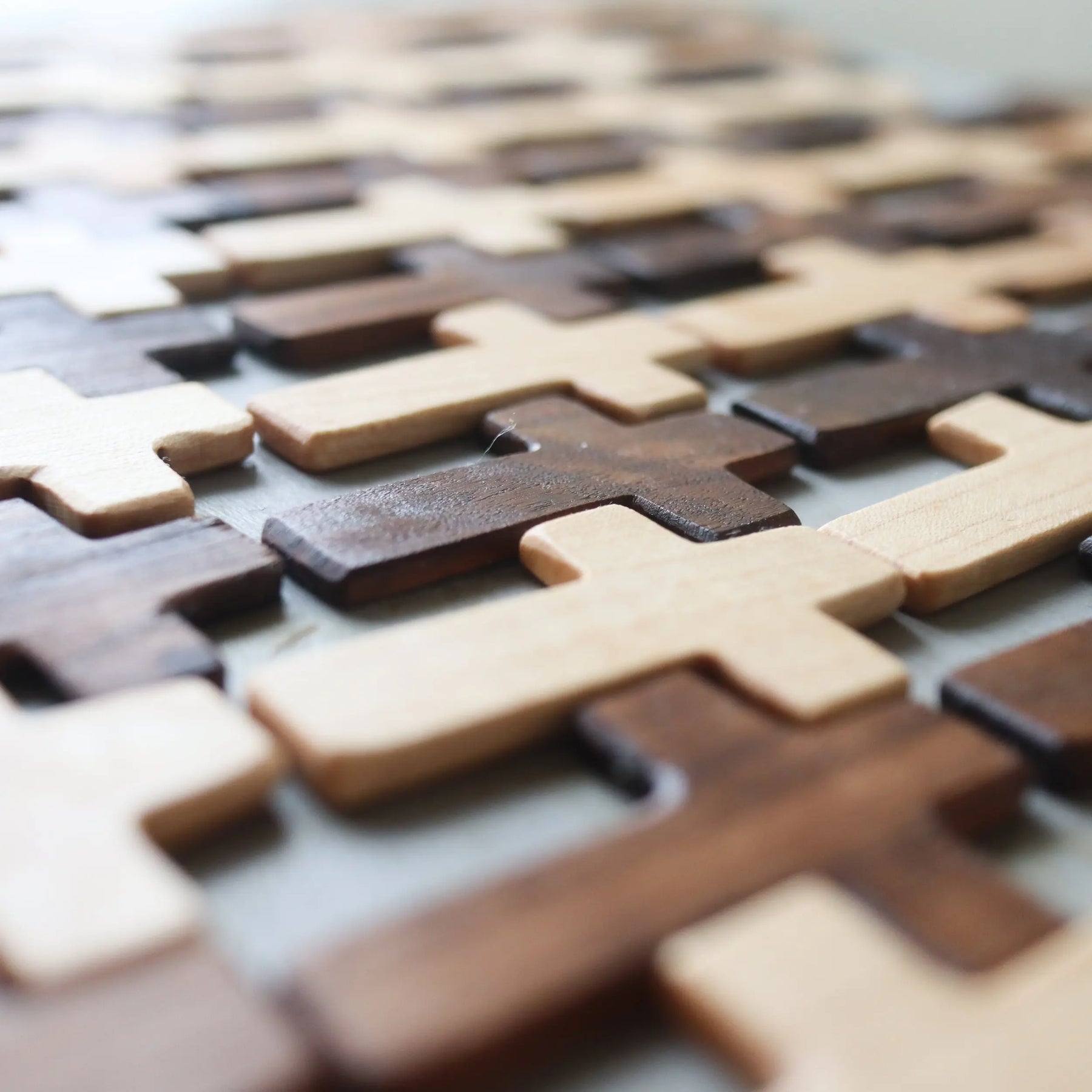 Thin pocket crosses made of light and dark wood arranged in a pattern.