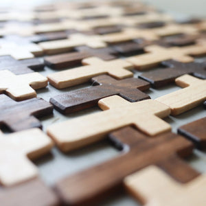 Thin pocket crosses made of light and dark wood arranged in a pattern.