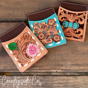 Three tooled leather credit card holders with floral designs in turquoise and pink.