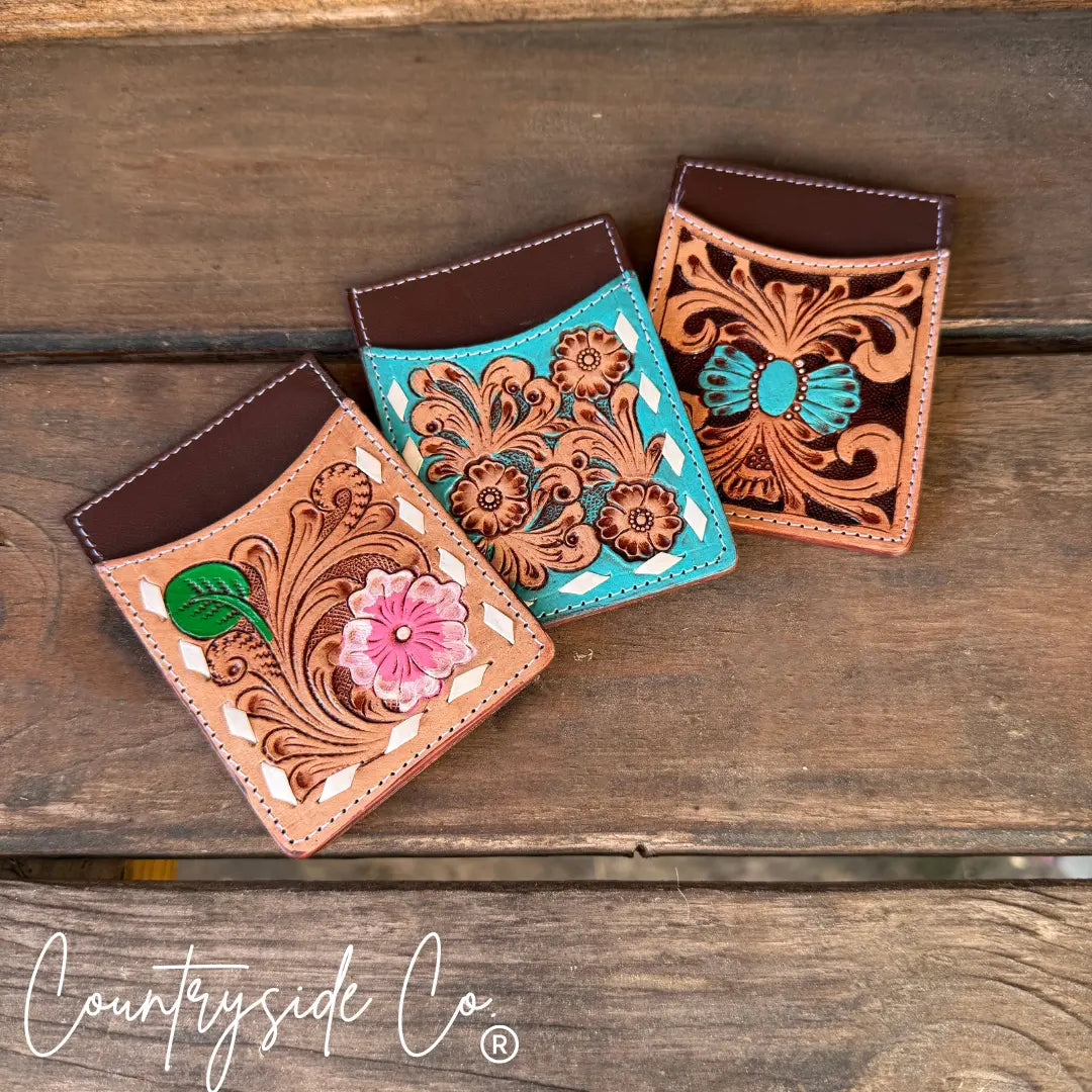 Tooled leather credit card holders with floral designs and turquoise accents.