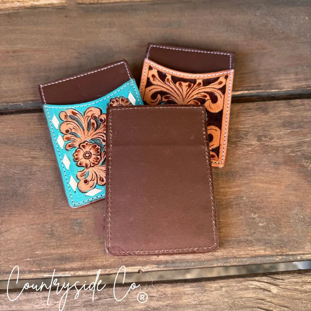 Tooled leather credit card holders in turquoise, tan, and brown with floral designs.