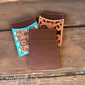 Tooled leather credit card holders in turquoise, tan, and brown with floral designs.