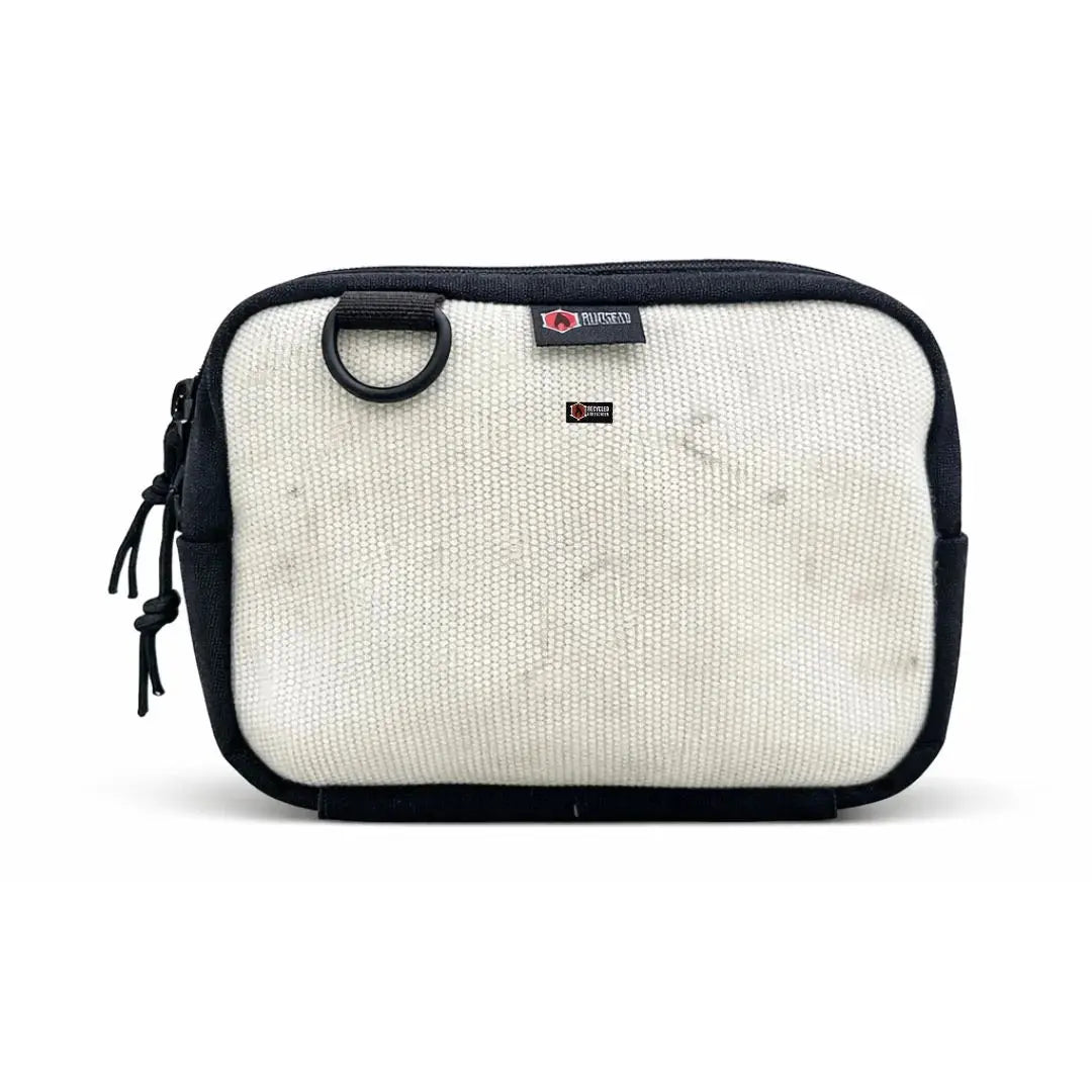 Off-white canvas fanny pack with black trim and a black D-ring.