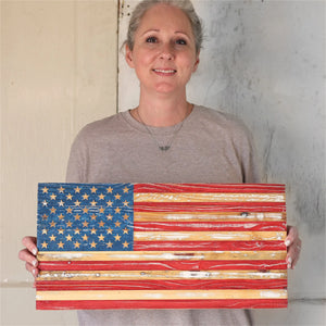 Rustic wooden American flag with hand-painted stars and stripes.