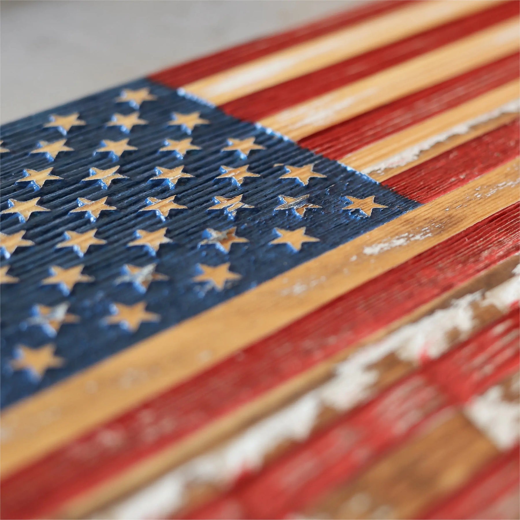 Close-up of a rustic wooden American flag with carved stars and stripes