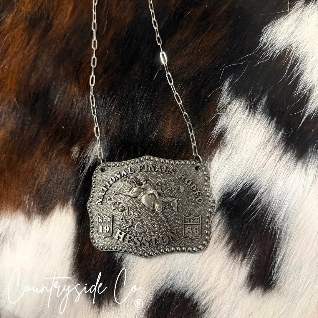 Silver NFR buckle necklace with horse rider design and paperclip chain.