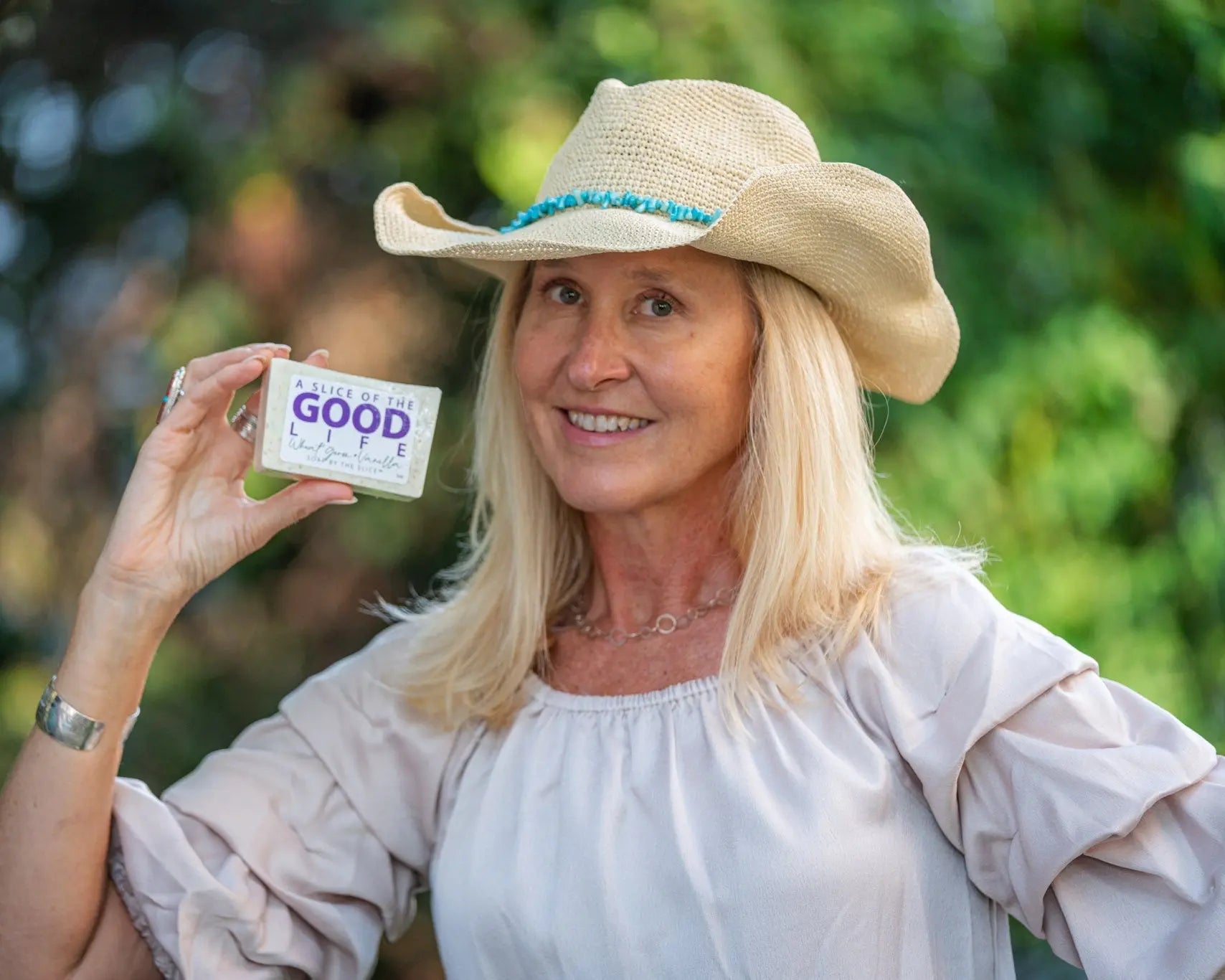 Woman in a cowboy hat holding a bar of Wheat Germ & Vanilla soap