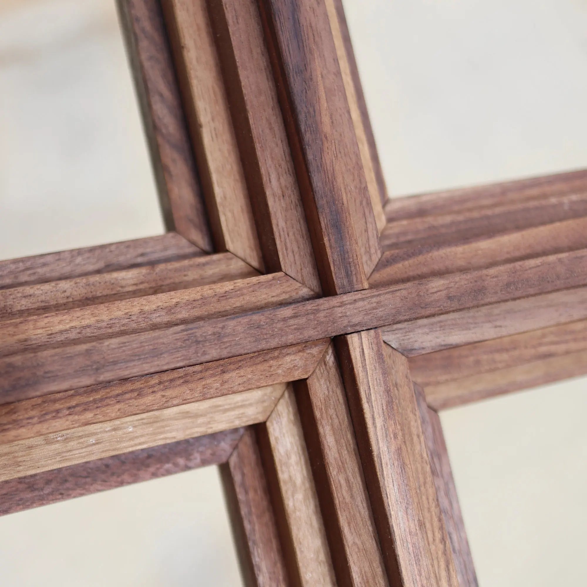 Close-up of a wooden cross made of layered walnut wood.