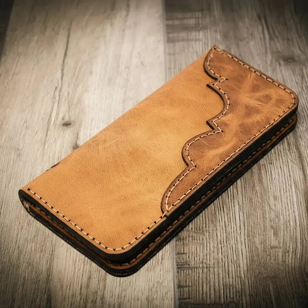 Brown leather Western long bifold wallet with decorative stitching on a wood surface.